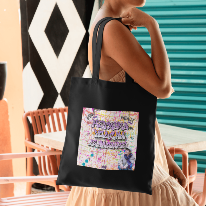 Woman holding black totebag with grafitti style Hey mama lyrics J-hope of BTS