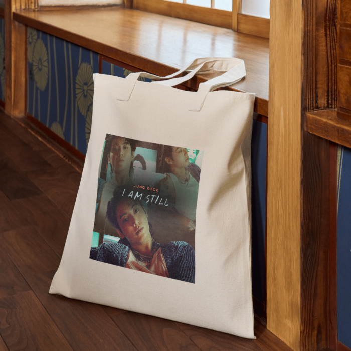 Beige canvas totebag with JK i am still promo docu design on the floor