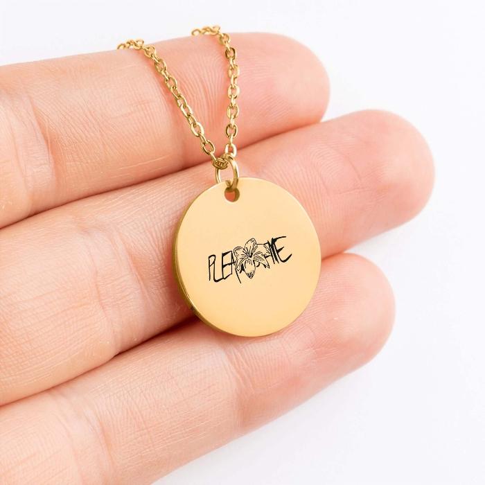 Golden coin necklace with JK birthflower tatoo design held in hand