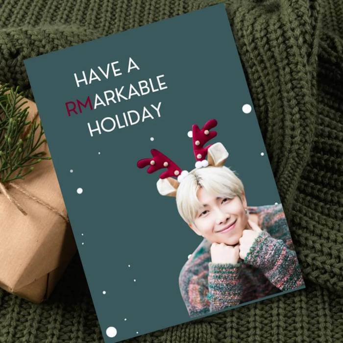 "Festive BTS Christmas postcard with RM in reindeer antlers and 'Have a RMarkable Holiday' message, perfect for ARMY fans."