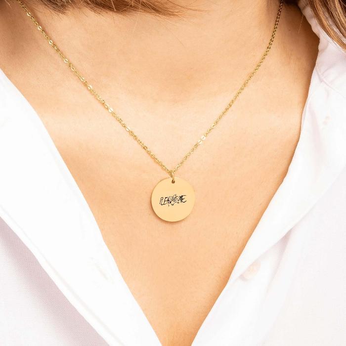 Woman wearing JK Tigerlily coin necklace with "Please love me" engraving in elegant style