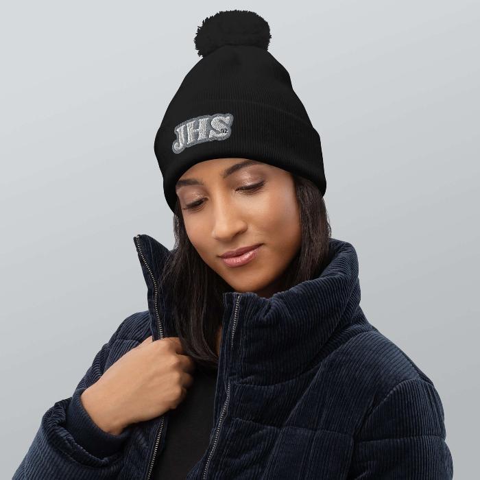 Woman wearing black J-Hope Hobi pompom beanie, cozy and stylish BTS accessory, perfect for chilly days and spreading warmth.