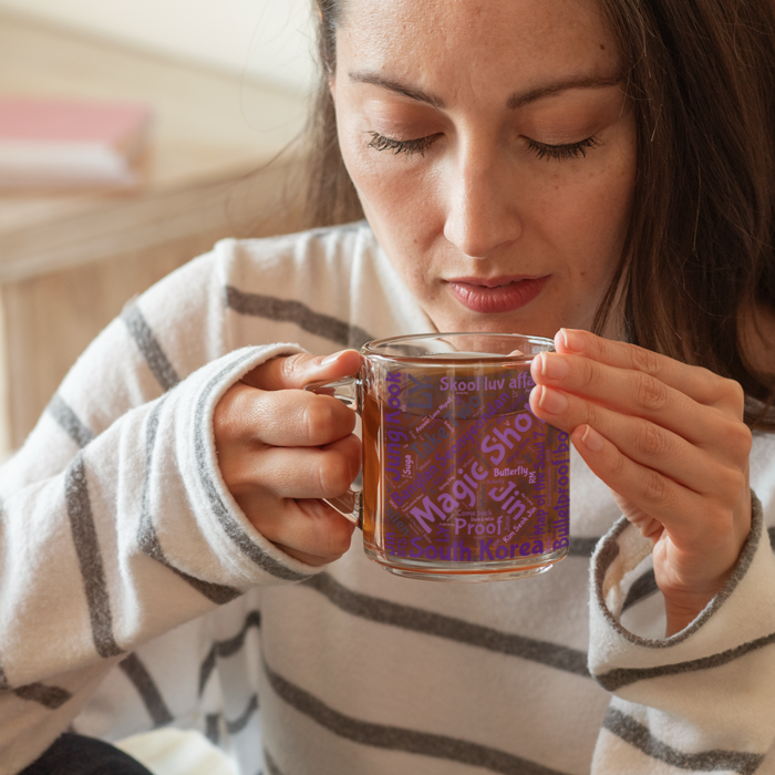 Woman holding a BTS magic shop glass mug design discography 10 years