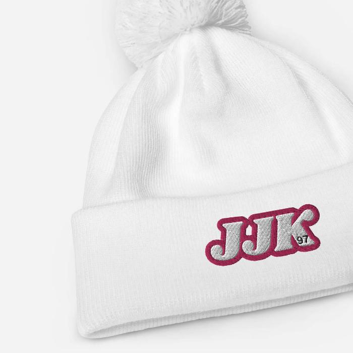 White pom pom beanie with "JJK" embroidery, inspired by Jung Kook. Soft-touch acrylic for warm winter adventures.